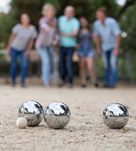 Males and females playing petanque in th park on holidays
